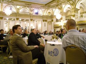 Attendees seated at tables and listening